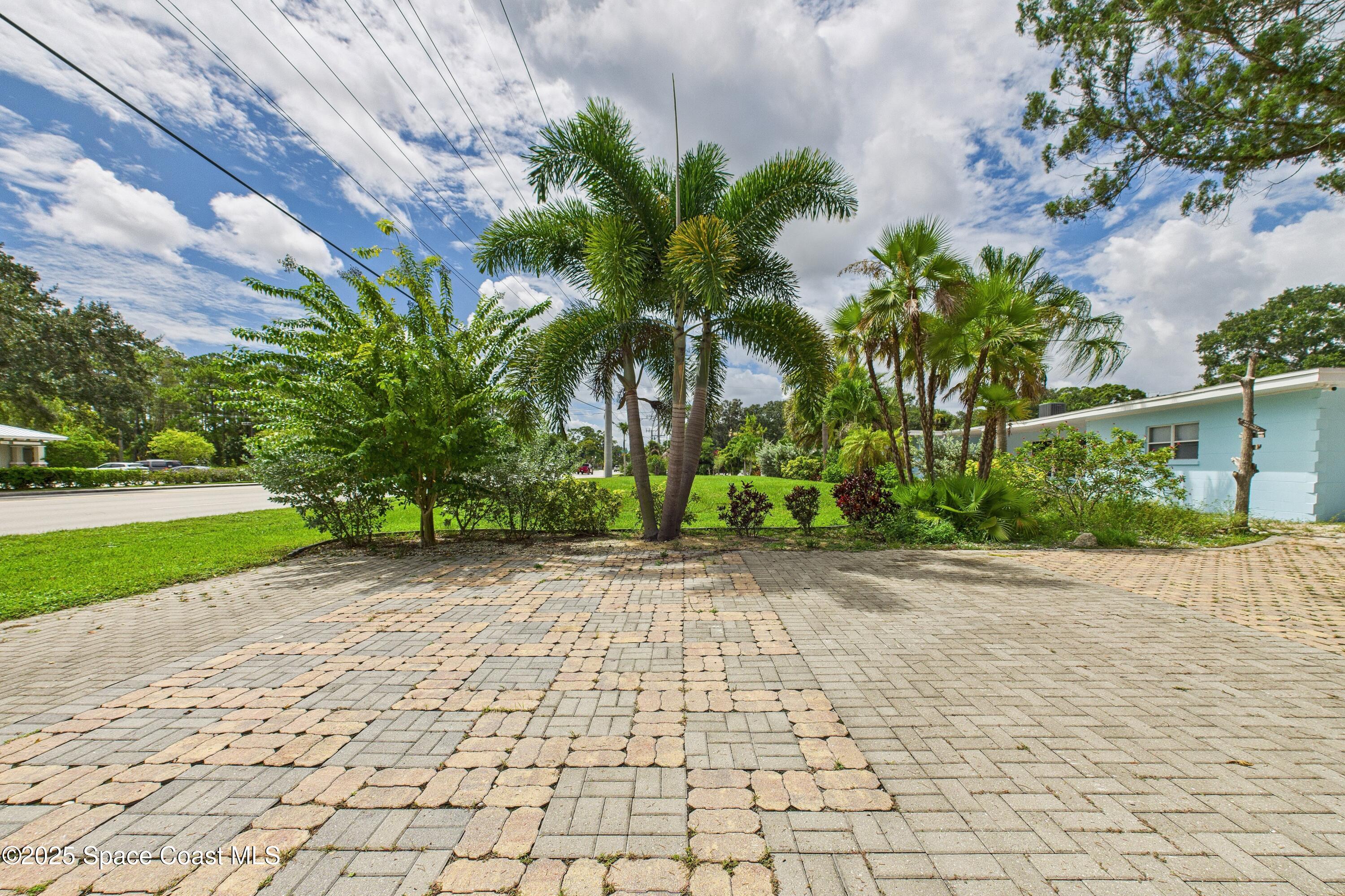 1340 South Wickham Road Melbourne, FL 32904 - Photo 33 of 50 a sidewalk with a building and trees in the background