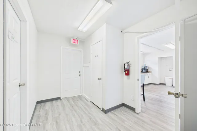 a view of a hallway with wooden floor and closet area