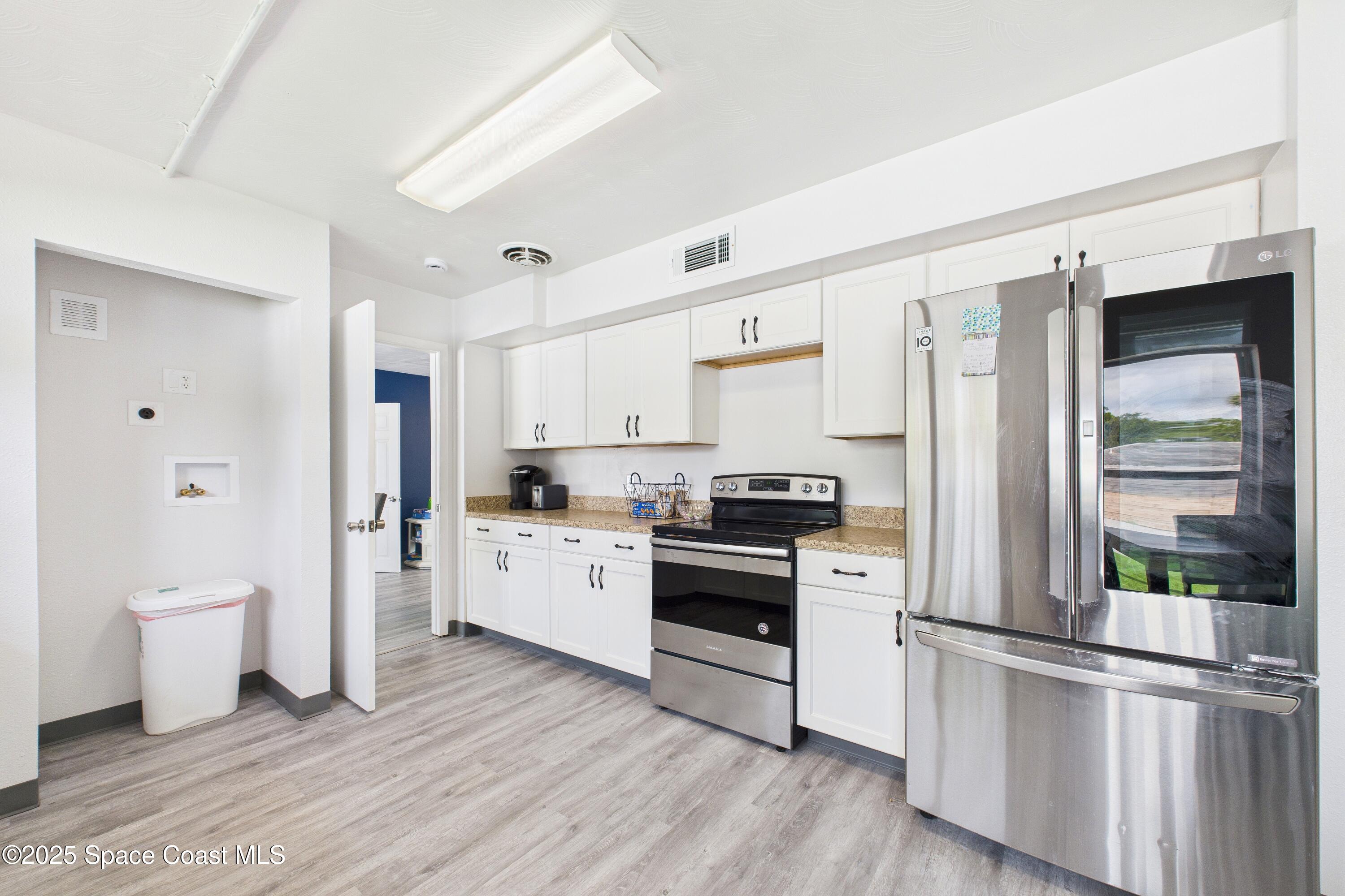 1340 South Wickham Road Melbourne, FL 32904 - Photo 41 of 50 a kitchen with stainless steel appliances a refrigerator sink and cabinets