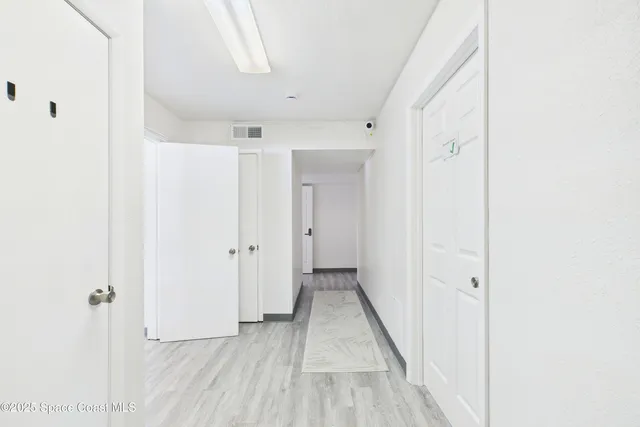 a view of a hallway with wooden floor