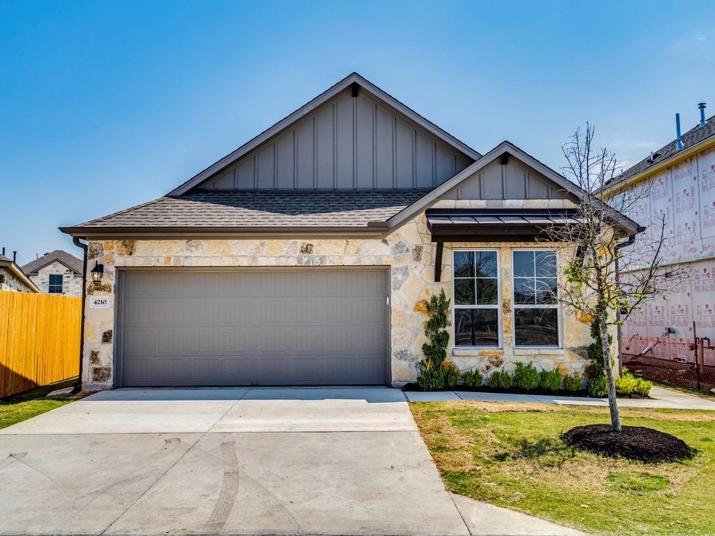 4210 Birdwatch Loop, Unit 2 Pflugerville, TX 78660 - Photo 28 of 31 A welcoming stone and wood-accented facade, complete with an attached garage, enhances curb appeal.