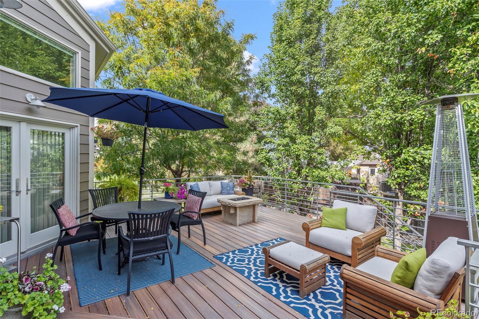 5236 Pinehurst Drive Boulder, CO 80301 - Photo 11 of 40 a view of a patio with a dining table and chairs under an umbrella with a barbeque