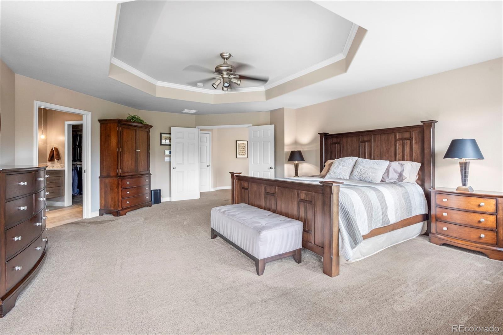 5236 Pinehurst Drive Boulder, CO 80301 - Photo 19 of 40 a spacious bedroom with a large bed and a chandelier