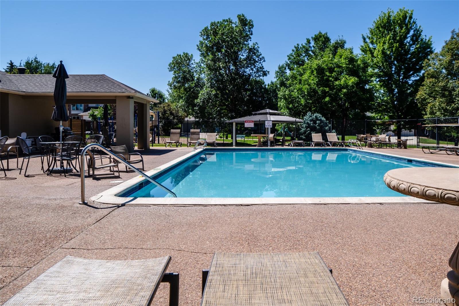 5236 Pinehurst Drive Boulder, CO 80301 - Photo 39 of 40 a view of a swimming pool with lawn chairs under an umbrella