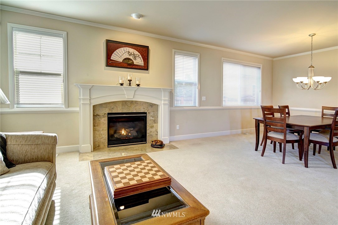 20706 37th Avenue Southeast Bothell, WA 98021 - Photo 12 of 32 a living room with furniture a dining table and a fireplace
