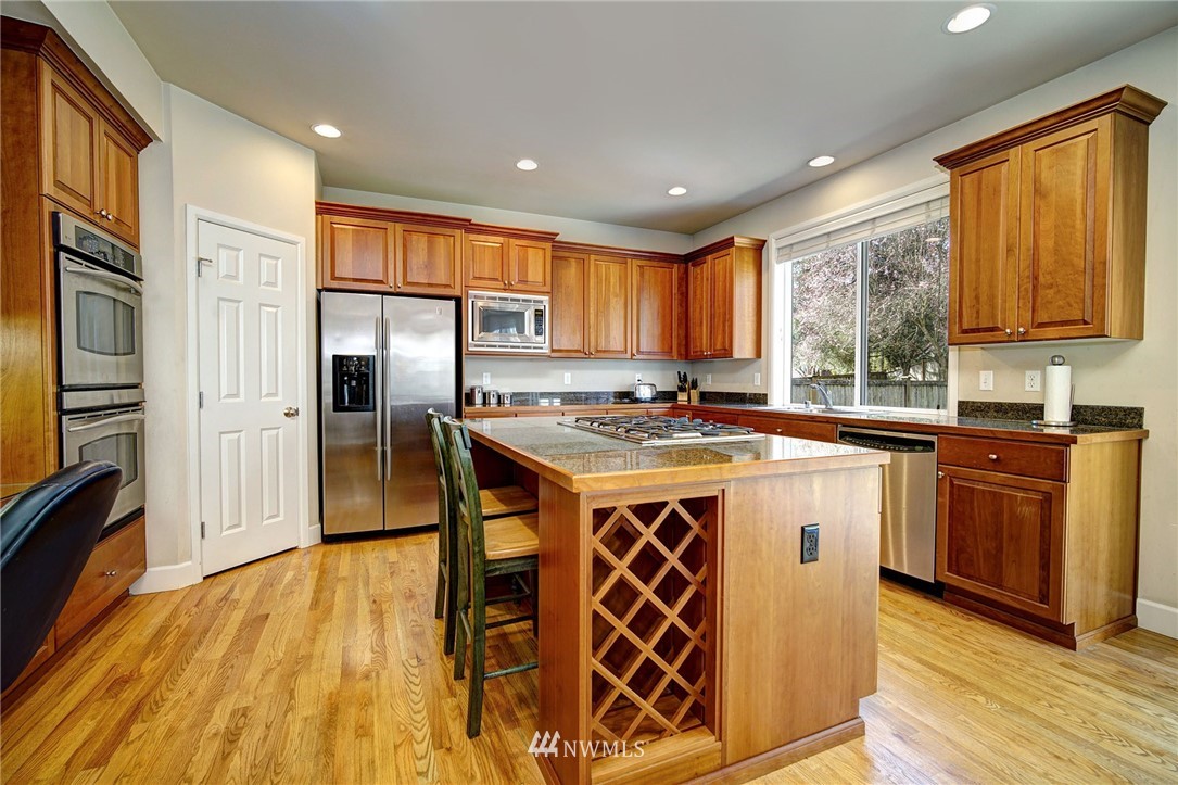 20706 37th Avenue Southeast Bothell, WA 98021 - Photo 4 of 32 a kitchen with stainless steel appliances granite countertop a sink stove and refrigerator