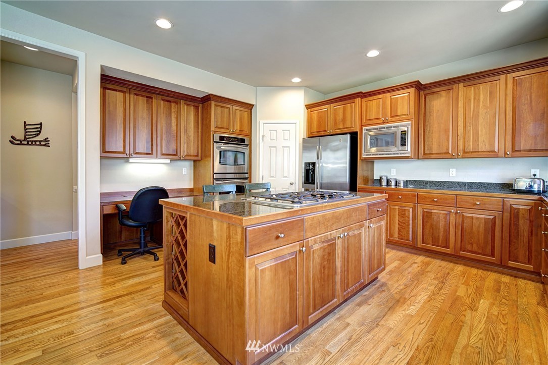 20706 37th Avenue Southeast Bothell, WA 98021 - Photo 5 of 32 a kitchen with wooden cabinets a sink dishwasher and a stove with wooden floor