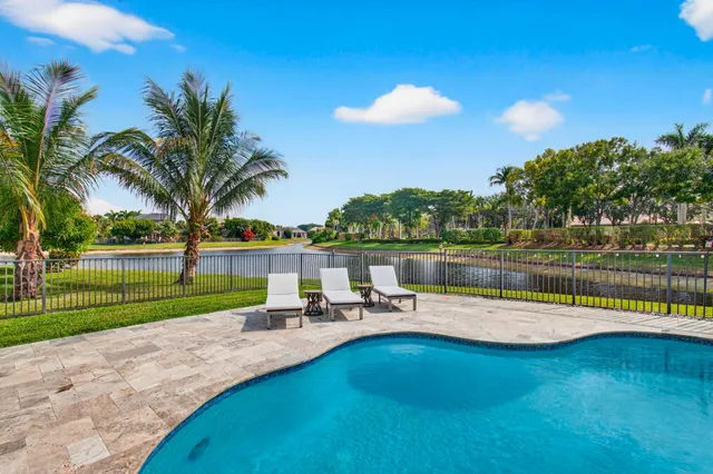 a view of a swimming pool with a patio and a lake view