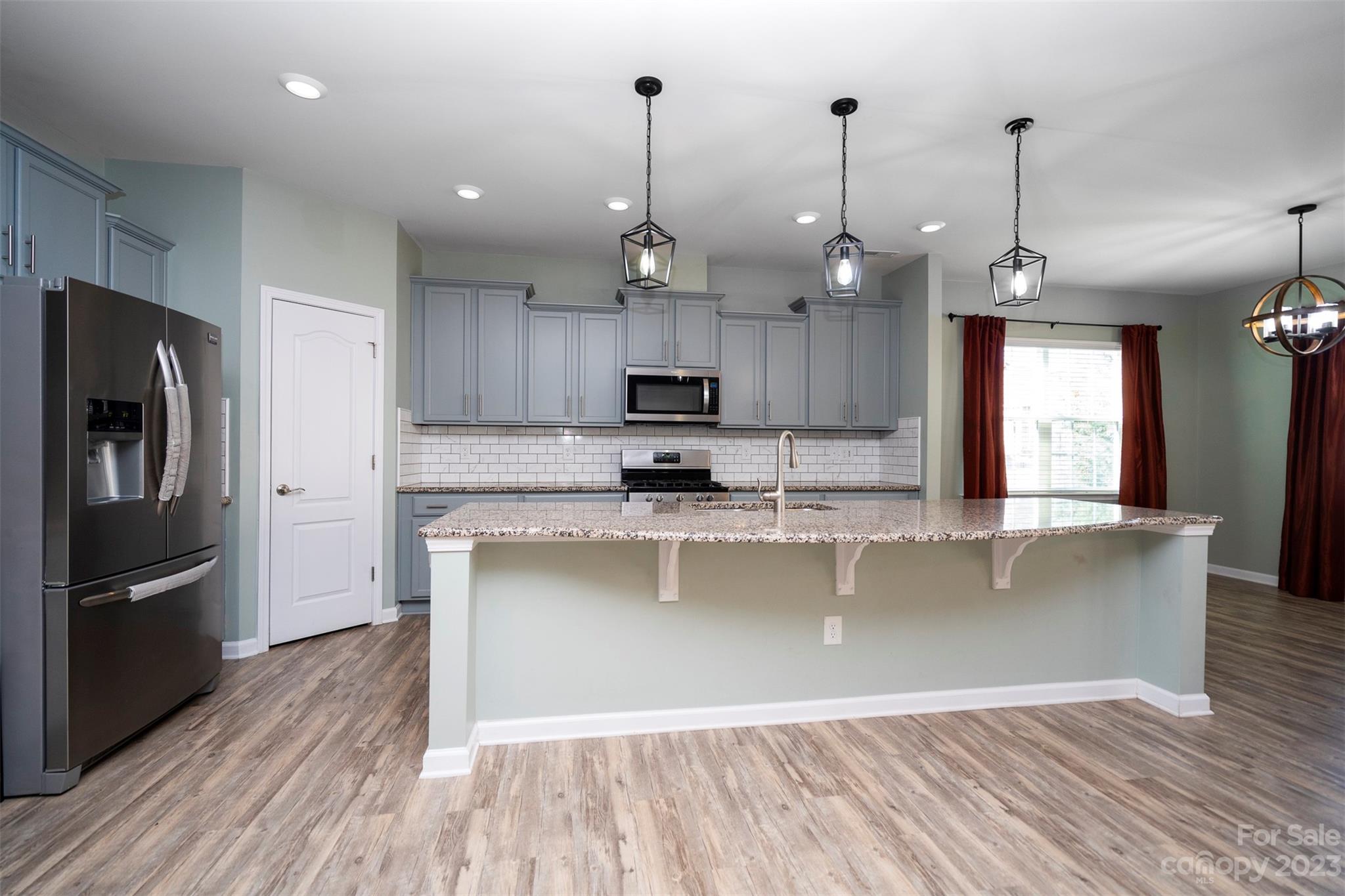 8202 Asher Chase Trail Lancaster, SC 29720 - Photo 12 of 42 a kitchen with stainless steel appliances granite countertop a refrigerator a sink dishwasher a stove and white countertops with wooden floor