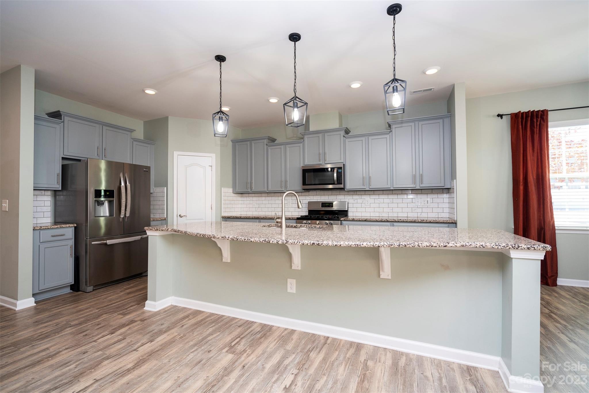 8202 Asher Chase Trail Lancaster, SC 29720 - Photo 13 of 42 a view of a kitchen with stainless steel appliances granite countertop a refrigerator a sink a stove and a wooden floors