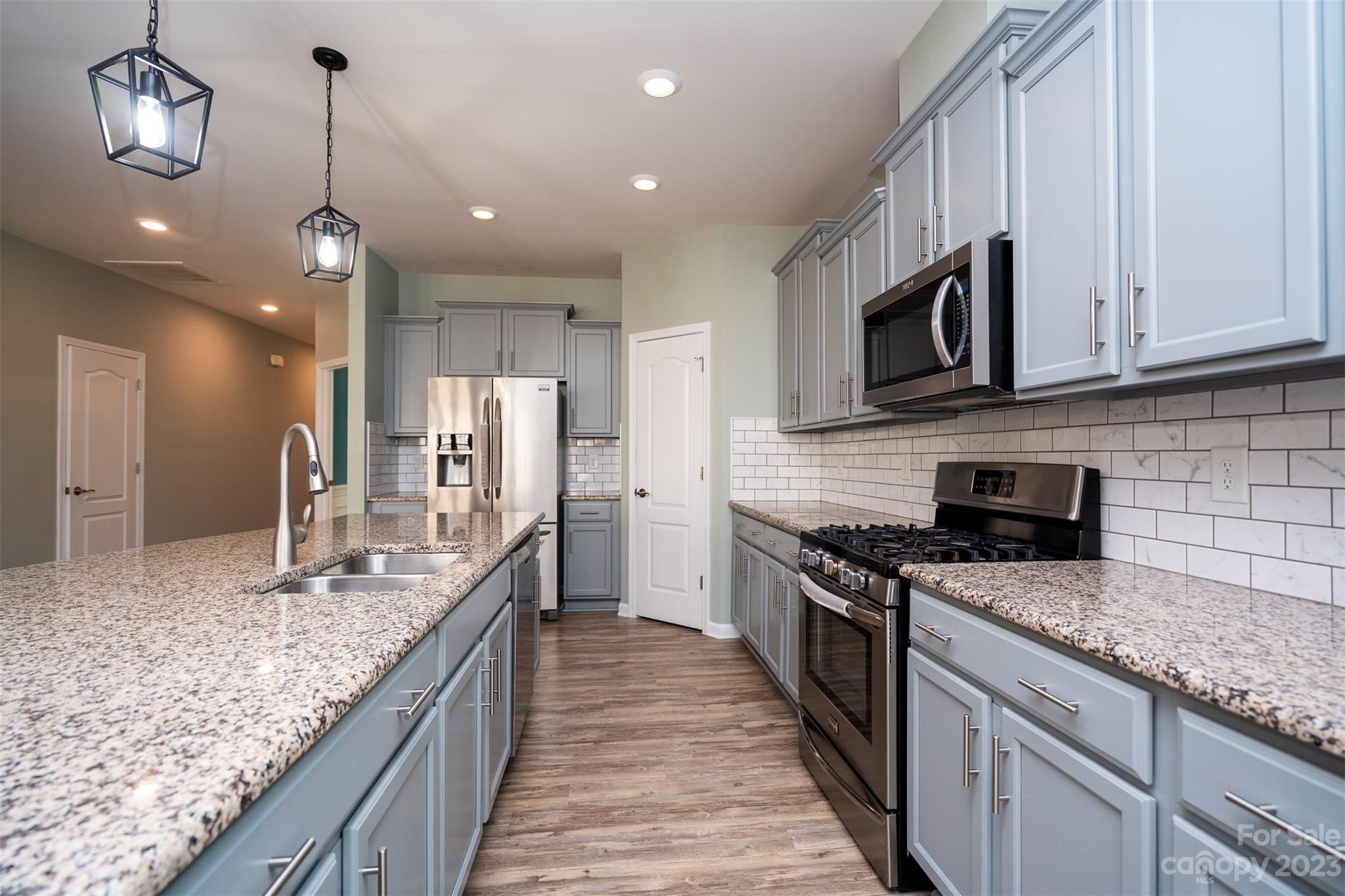 8202 Asher Chase Trail Lancaster, SC 29720 - Photo 14 of 42 a kitchen with stainless steel appliances granite countertop a sink a stove oven a kitchen island with cabinets and wooden floor