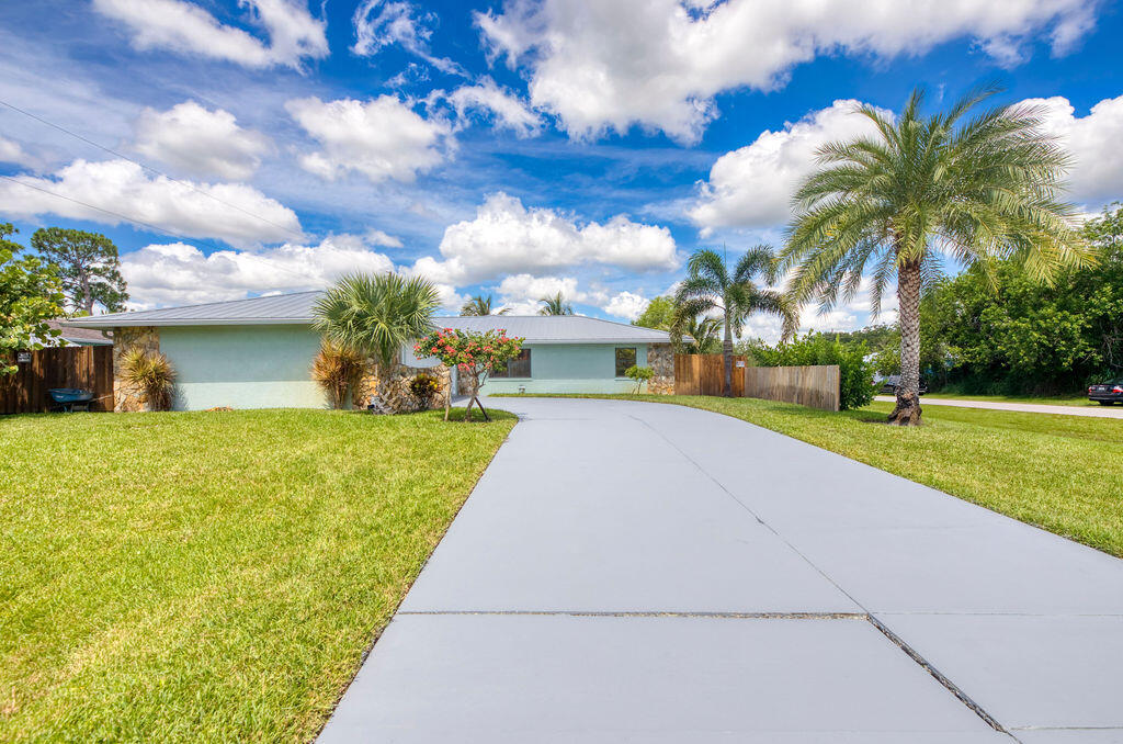 2402 Southeast Pinero Road Port St. Lucie, FL 34952 - Photo 2 of 45 a view of a swimming pool with a yard