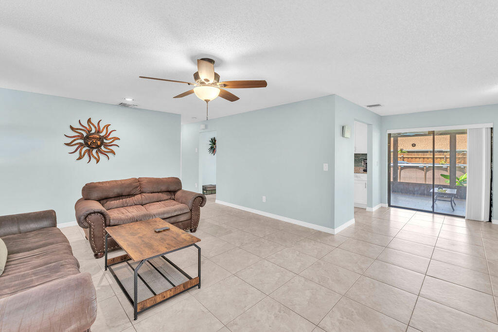 2402 Southeast Pinero Road Port St. Lucie, FL 34952 - Photo 30 of 45 a living room with furniture a dining table and a chandelier