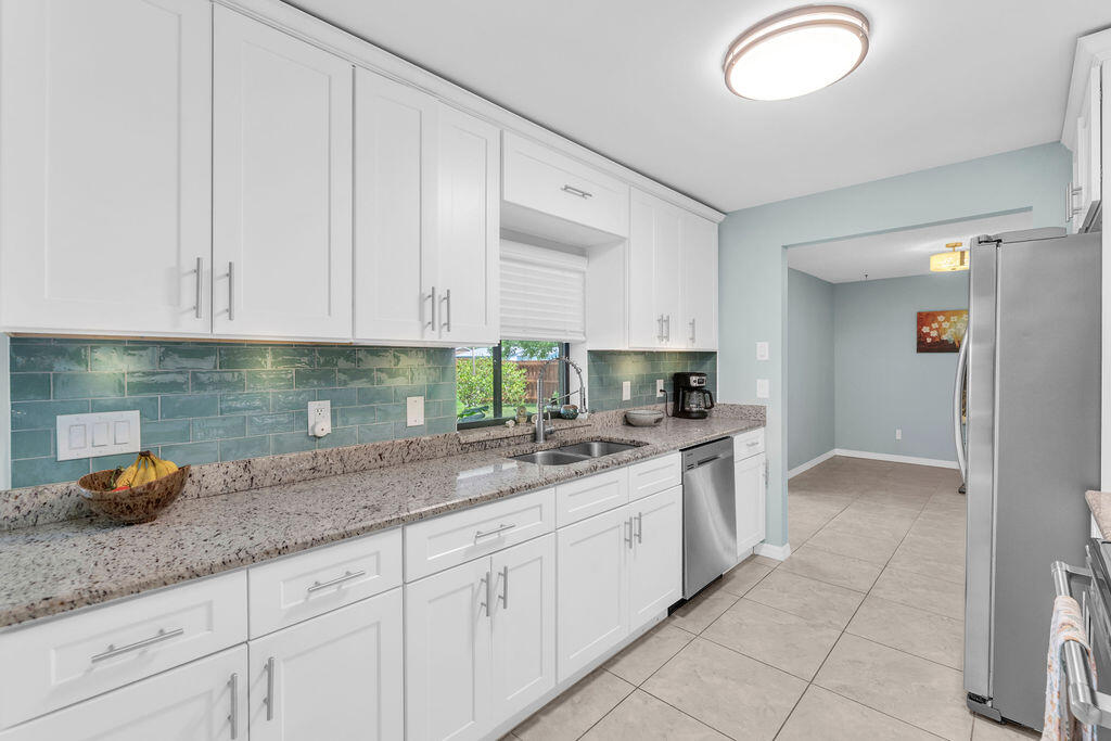 2402 Southeast Pinero Road Port St. Lucie, FL 34952 - Photo 34 of 45 a kitchen with granite countertop white cabinets and sink