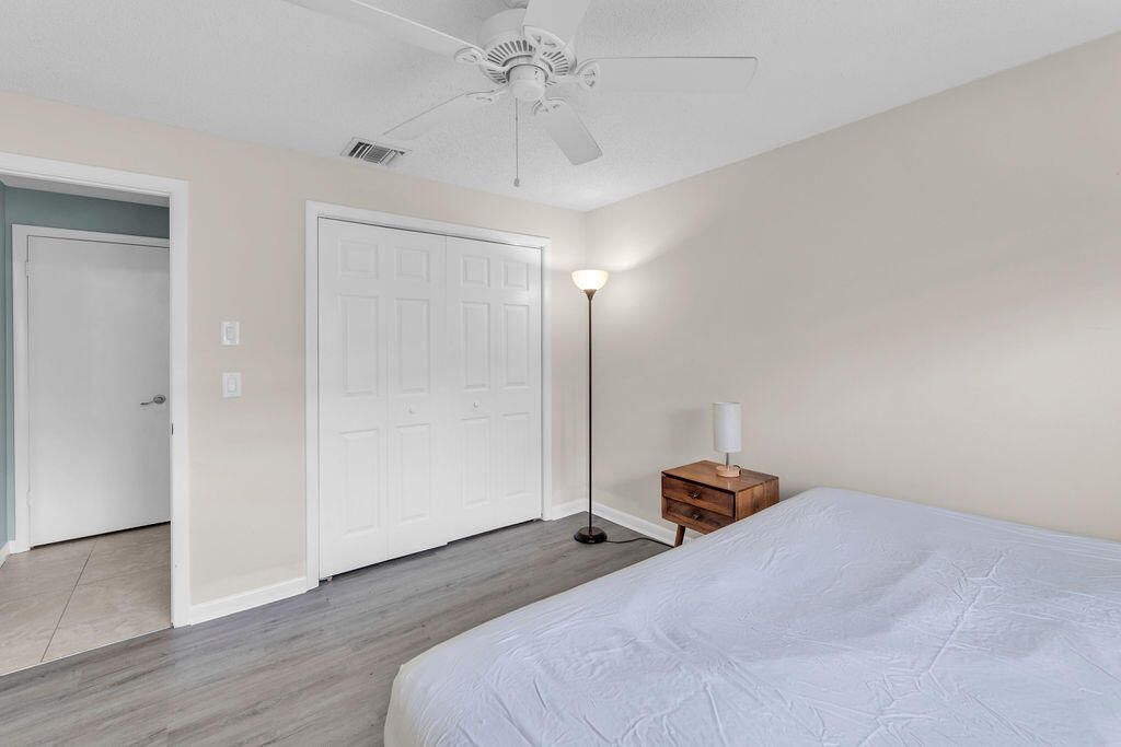 2402 Southeast Pinero Road Port St. Lucie, FL 34952 - Photo 39 of 45 a bedroom with a bed and wooden floor