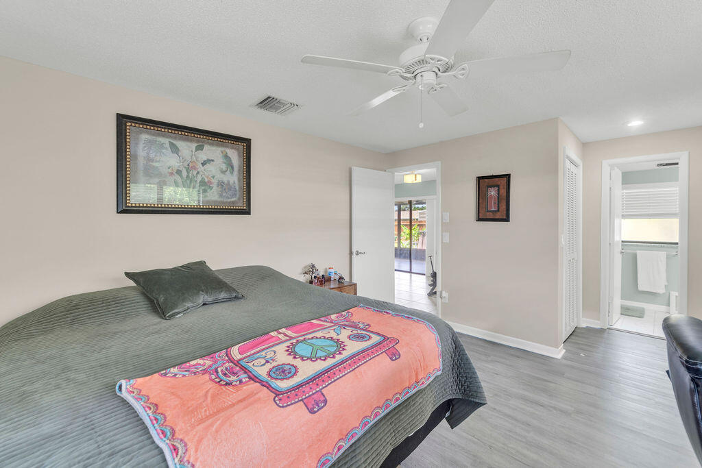 2402 Southeast Pinero Road Port St. Lucie, FL 34952 - Photo 42 of 45 a bedroom with a bed and a lamp