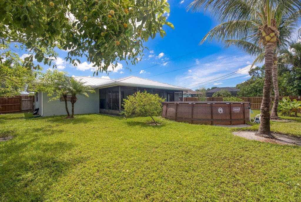 2402 Southeast Pinero Road Port St. Lucie, FL 34952 - Photo 9 of 45 a house with a big yard and large trees