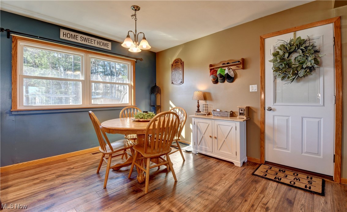 15235 Stocker Ridge Road Southwest Newcomerstown, OH 43832 - Photo 19 of 37 Dining area featuring a healthy amount of sunlight, light hardwood / wood-style flooring, and a chandelier