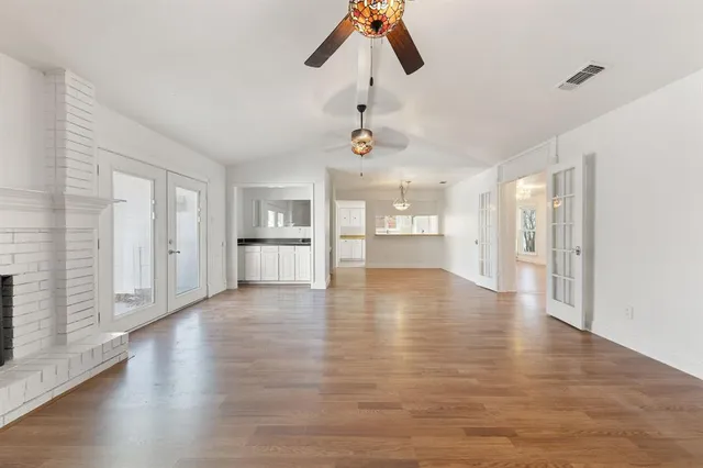 a view of empty room with wooden floor and window