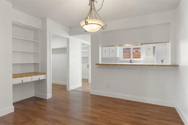 a view of a kitchen with wooden floor and a window