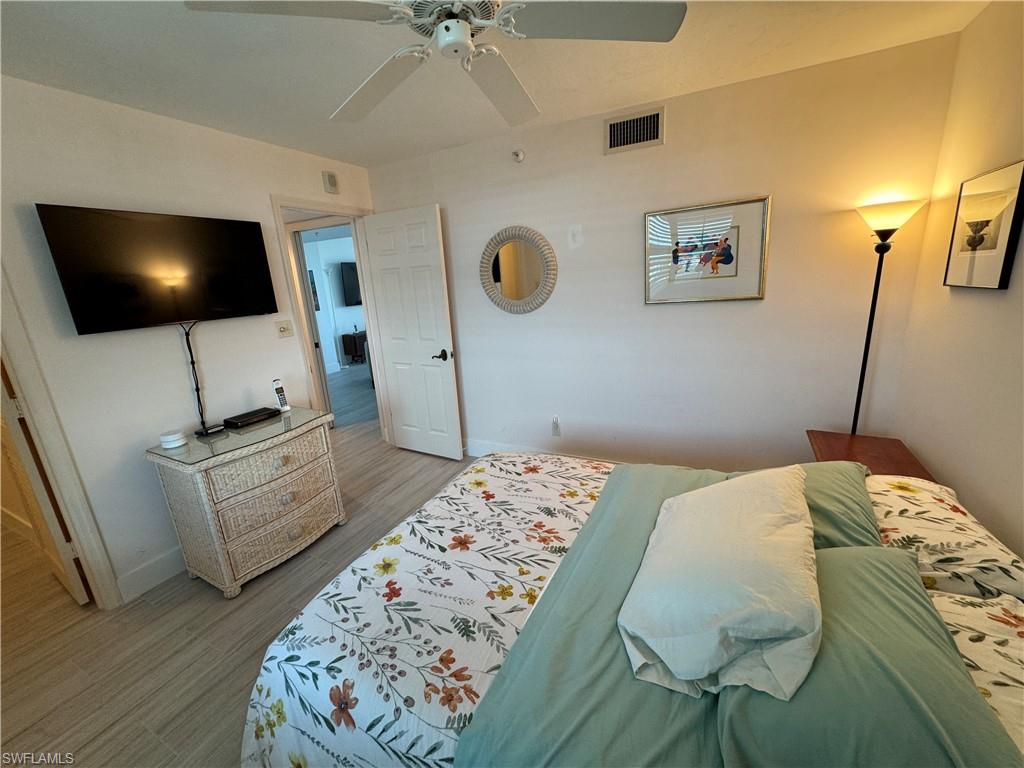 6573 Marissa Loop, Unit 902 Naples, FL 34108 - Photo 12 of 26 a bedroom with a bed and flat screen tv