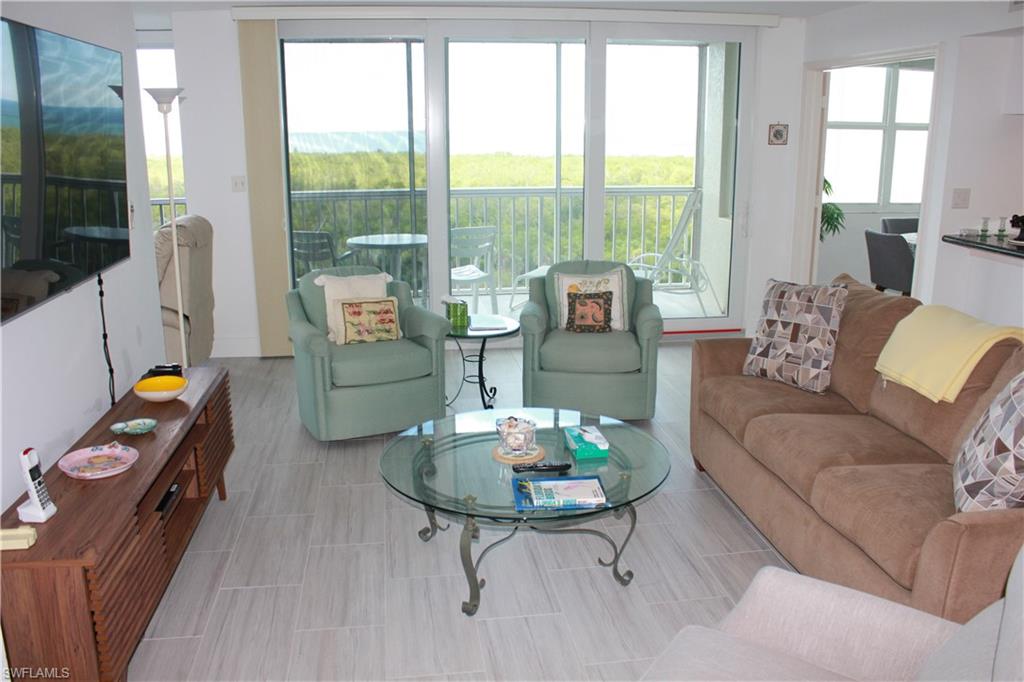 6573 Marissa Loop, Unit 902 Naples, FL 34108 - Photo 5 of 26 a living room with furniture and a floor to ceiling window