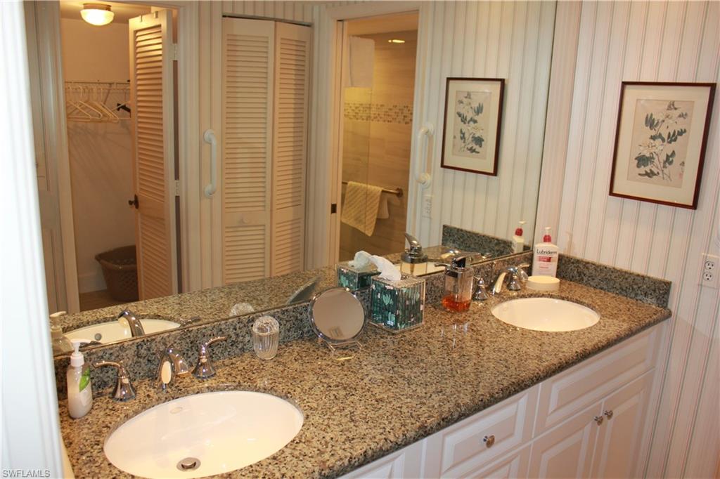 6573 Marissa Loop, Unit 902 Naples, FL 34108 - Photo 10 of 26 a bathroom with a granite countertop sink and a mirror