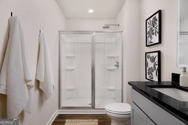 a bathroom with a granite countertop sink toilet and shower