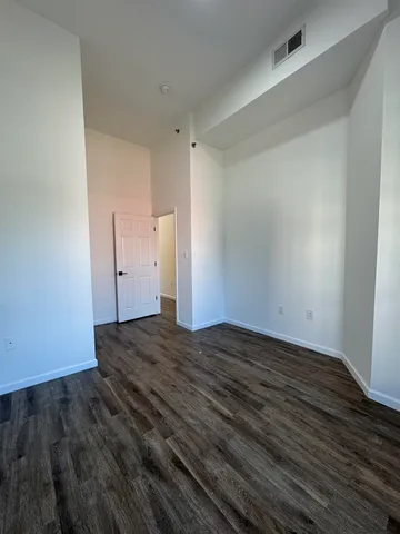 a view of empty room with wooden floor