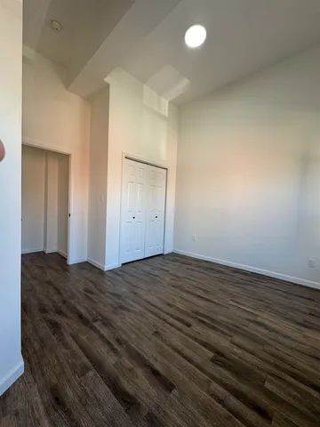 a view of empty room with wooden floor