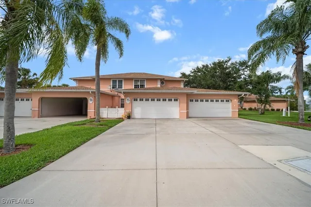 a view of a house with a yard and palm trees