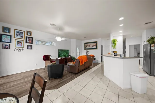 a living room with furniture and a dining table with kitchen view