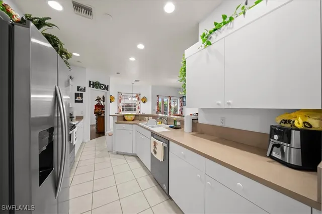 a kitchen with granite countertop a refrigerator and stainless steel appliances