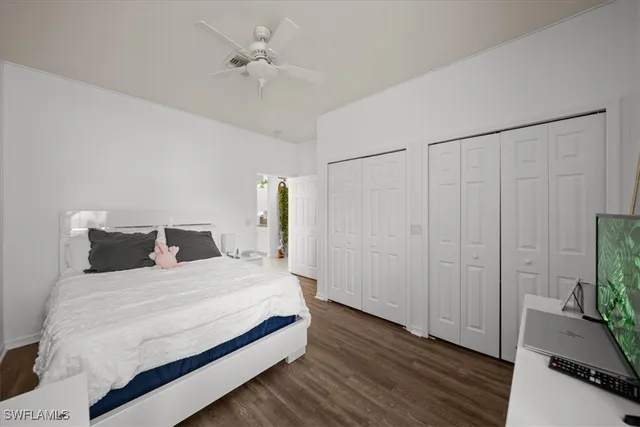 a bedroom with a bed table and a flat screen tv