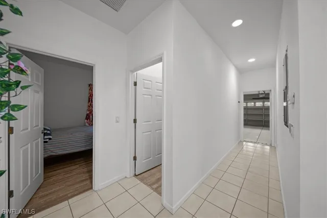 a view of hallway with walk in closet and wooden floor