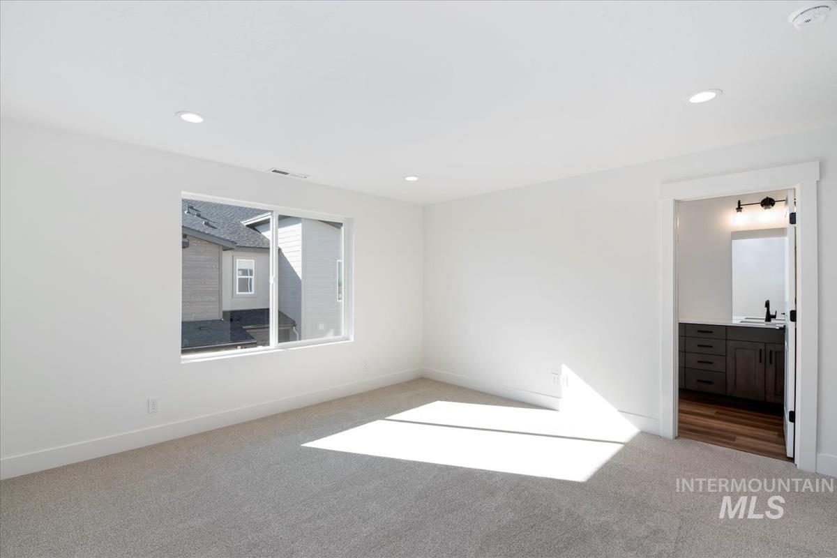 752 South Calhoun Lane Star, ID 83669 - Photo 17 of 45 Spacious room featuring light gray carpeting, recessed lighting, and a large window