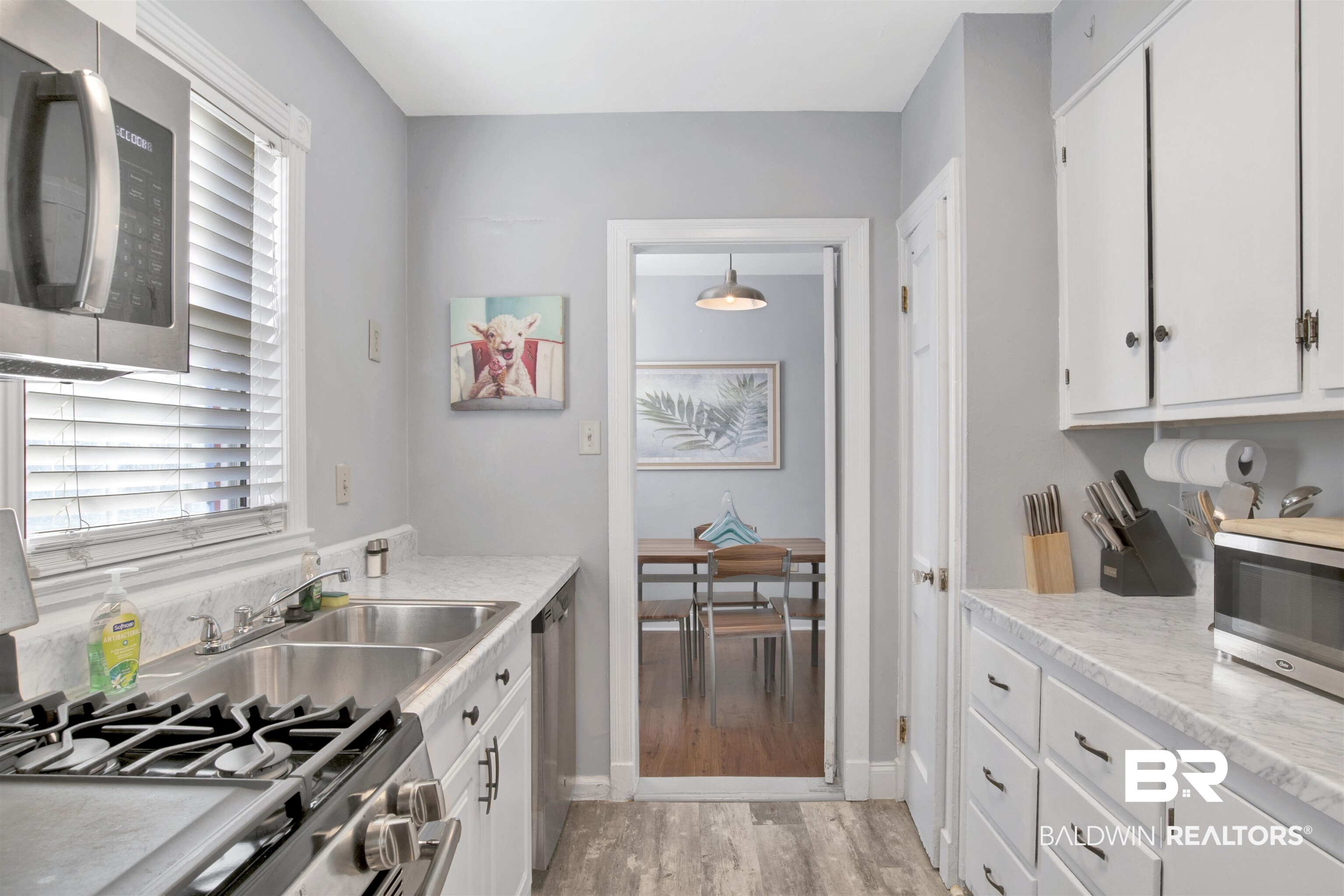 214 Upham Street, Unit 7A Mobile, AL 36607 - Photo 6 of 35 Kitchen with appliances with stainless steel finishes, white cabinetry, and light wood-style floors
