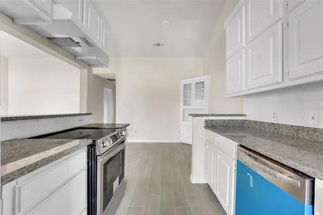 a kitchen with granite countertop a sink and a stove