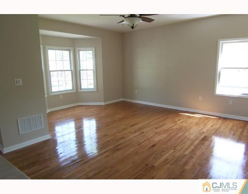 1117 New Dover Road Edison, NJ 08820 - Photo 3 of 8 a view of empty room with wooden floor and fan