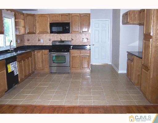 1117 New Dover Road Edison, NJ 08820 - Photo 5 of 8 a open kitchen with stainless steel appliances a stove a sink and a microwave