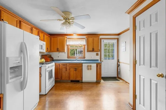 a kitchen with stainless steel appliances a refrigerator a sink a stove and white cabinets