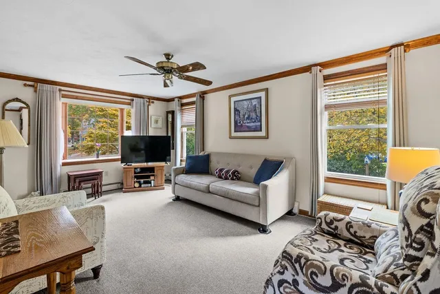 a living room with furniture a flat screen tv and a window