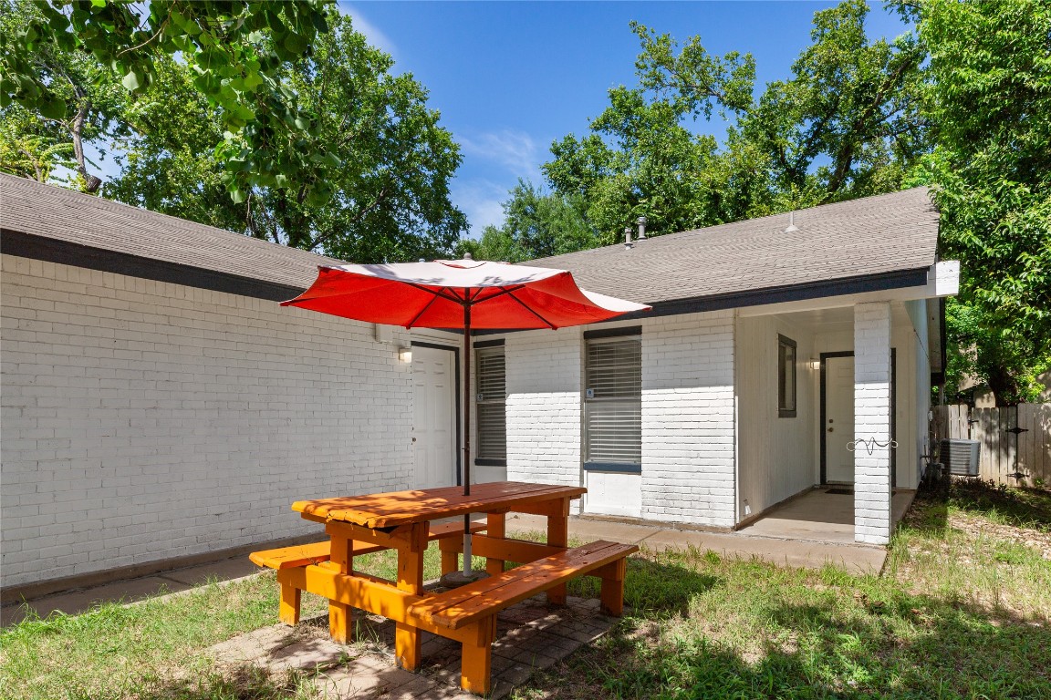 a backyard of a house with table and chairs
