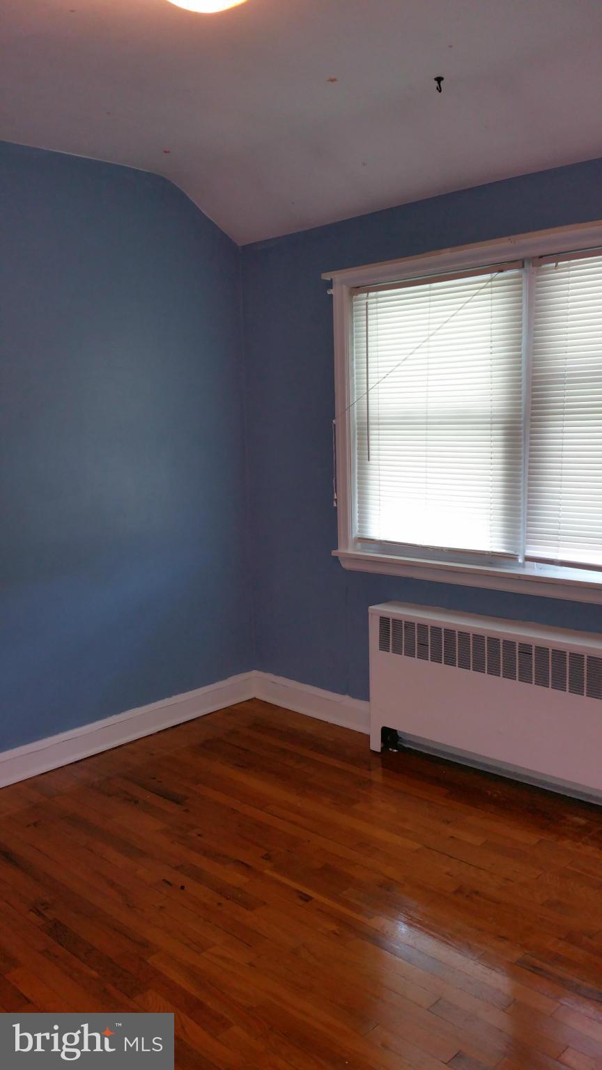 3902 Colchester Road Baltimore, MD 21229 - Photo 16 of 27 an empty room with wooden floor and windows