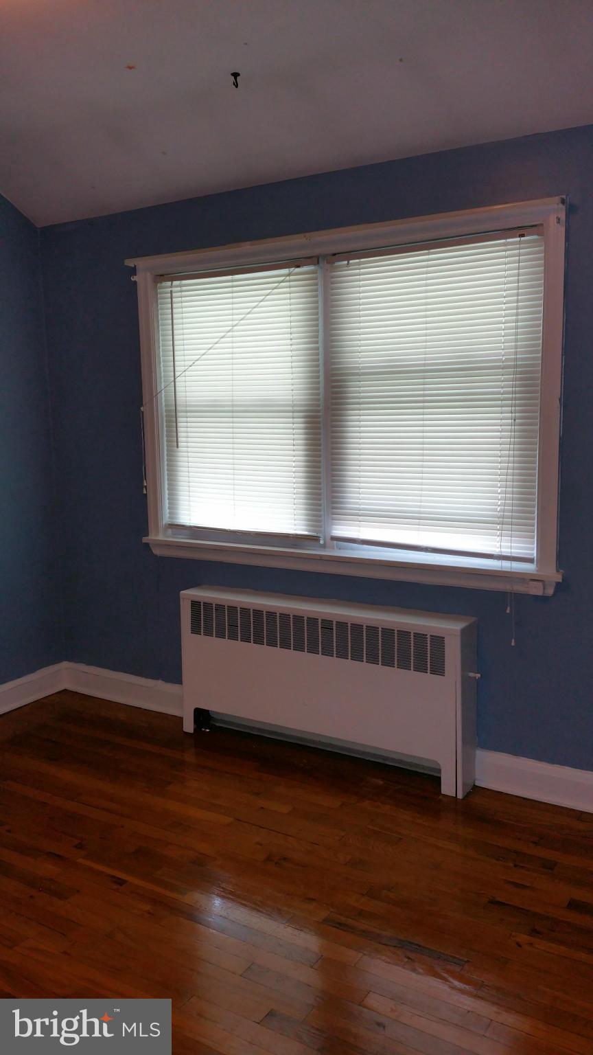 3902 Colchester Road Baltimore, MD 21229 - Photo 17 of 27 an empty room with wooden floor and a window