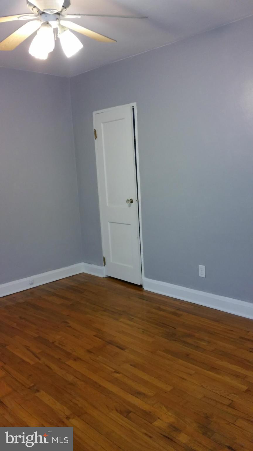 3902 Colchester Road Baltimore, MD 21229 - Photo 20 of 27 a view of an empty room with wooden floor and white walls