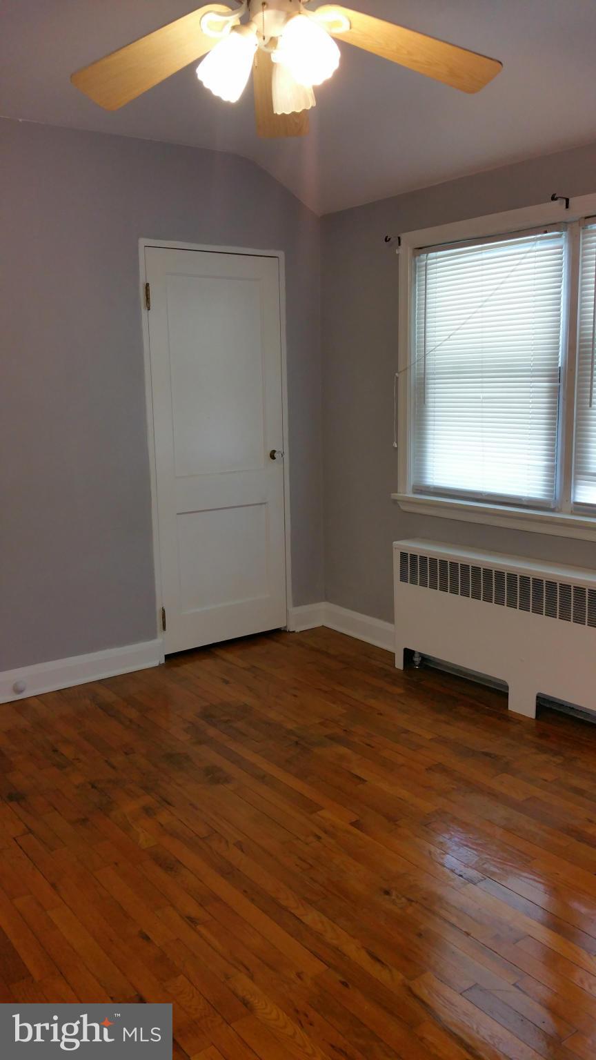 3902 Colchester Road Baltimore, MD 21229 - Photo 21 of 27 a view of an empty room with wooden floor and a window