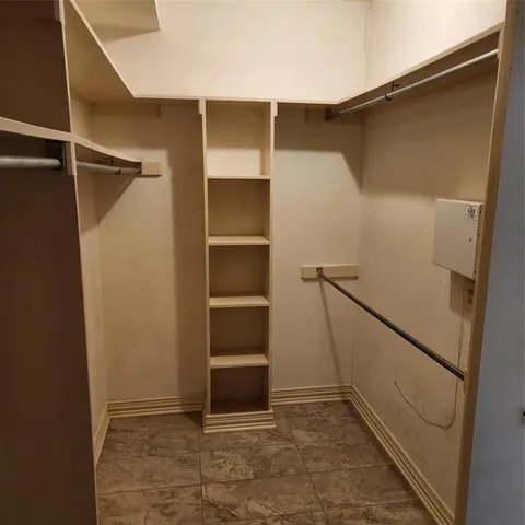 a view of walk in closet with empty racks