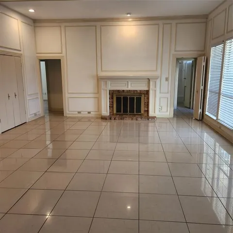 a view of a livingroom with a fireplace cabinet and window