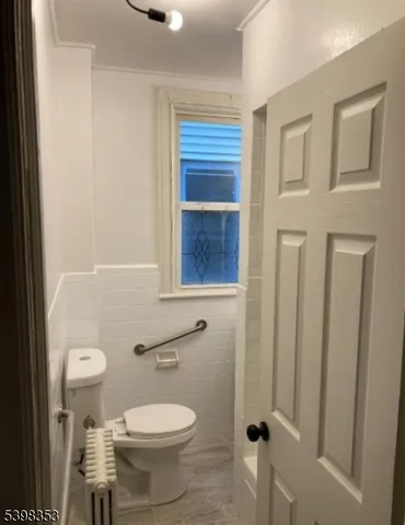 a bathroom with a toilet a sink and a window